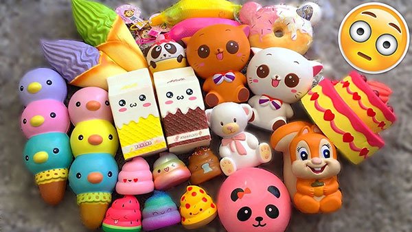 Một nhóm đồ chơi squishy với nhiều hình dạng và màu sắc khác nhau, bao gồm động vật và đồ ăn.