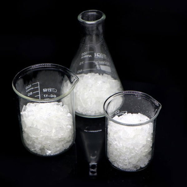 Ba cốc thủy tinh chứa đầy tinh thể trắng, đặt trên nền đen.