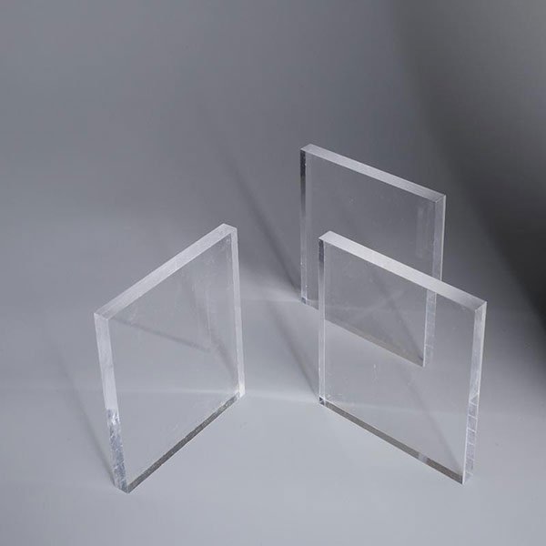 thuy-tinh-huu-co-duoi-dang-kinh Ba tấm acrylic trong suốt được đặt đứng trên bề mặt phẳng màu xám.
