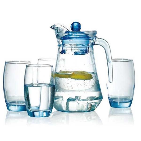 Bình nước trong suốt với lát chanh và bốn ly thủy tinh chứa nước, đặt trên nền trắng.