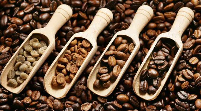 Khám phá công thức cà phê tuyệt đỉnh: Bí quyết bùng nổ doanh thu không thể cưỡng lại! 4 Bốn muỗng gỗ chứa các loại hạt cà phê với mức độ rang khác nhau trên nền hạt cà phê.