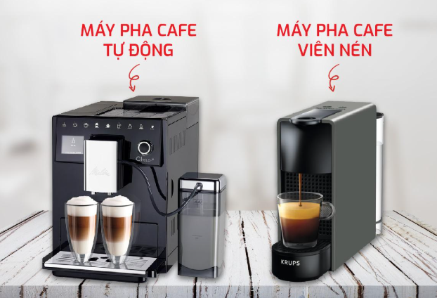Hai loại m&aacute;y pha cafe tr&ecirc;n b&agrave;n gỗ: m&aacute;y pha cafe tự động b&ecirc;n tr&aacute;i, m&aacute;y pha cafe vi&ecirc;n n&eacute;n b&ecirc;n phải.