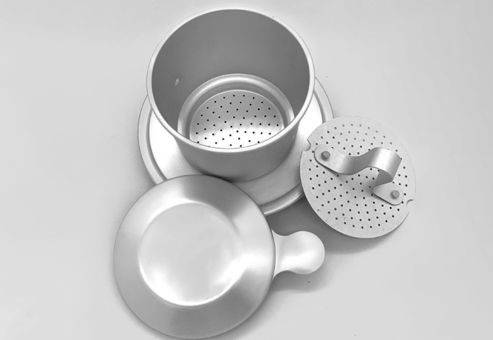 Bộ phin pha c&agrave; ph&ecirc; bằng kim loại m&agrave;u bạc, gồm nắp, th&acirc;n phin v&agrave; đế, được bố tr&iacute; tr&ecirc;n nền trắng.