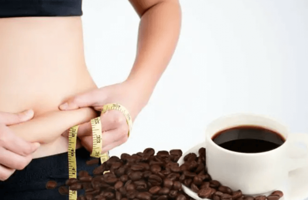 Người cầm thước dây đo vòng eo, bên cạnh là ly cà phê và hạt cà phê trên bàn.
