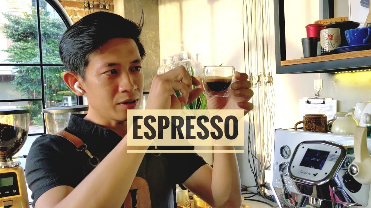 Khám Phá Gu Cà Phê Nguyên Chất - Xu Hướng Thưởng Thức Hiện Đại Của Giới Trẻ! 6 Người đàn ông cầm ly espresso nhỏ trong quán cà phê, phía sau là máy pha cà phê và dụng cụ pha chế.