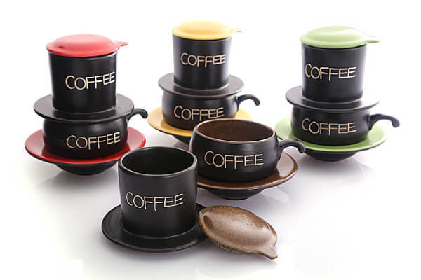 Bộ ly cà phê phin nhiều màu sắc khác nhau, với chữ "COFFEE" trên thân ly, đặt trên nền trắng.