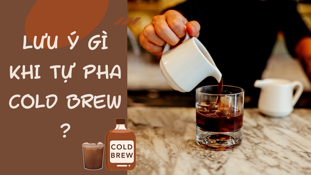 Người đổ c&agrave; ph&ecirc; từ b&igrave;nh nhỏ v&agrave;o ly tr&ecirc;n b&agrave;n đ&aacute; cẩm thạch, b&ecirc;n cạnh l&agrave; chữ hướng dẫn pha Cold Brew.