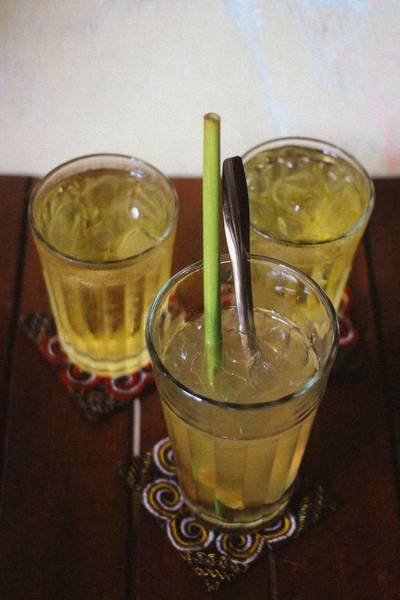 Ba ly tr&agrave; đ&aacute; đặt tr&ecirc;n b&agrave;n gỗ, mỗi ly c&oacute; ống h&uacute;t v&agrave; th&igrave;a inox, đế l&oacute;t ly c&oacute; hoa văn.