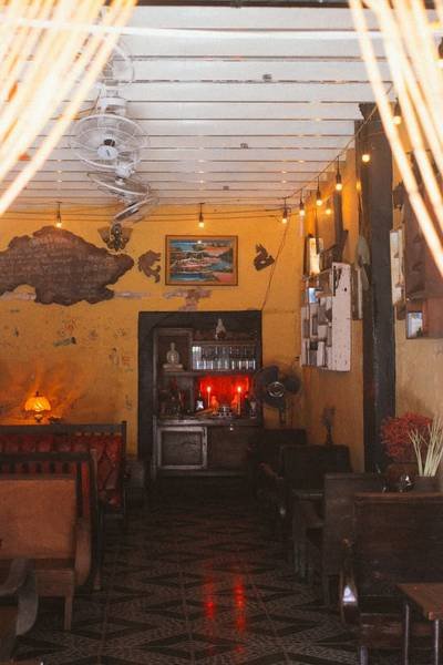 Qu&aacute;n c&agrave; ph&ecirc; với trang tr&iacute; cổ điển, tường v&agrave;ng, b&agrave;n ghế gỗ, v&agrave; đ&egrave;n treo mang lại kh&ocirc;ng gian ấm c&uacute;ng.