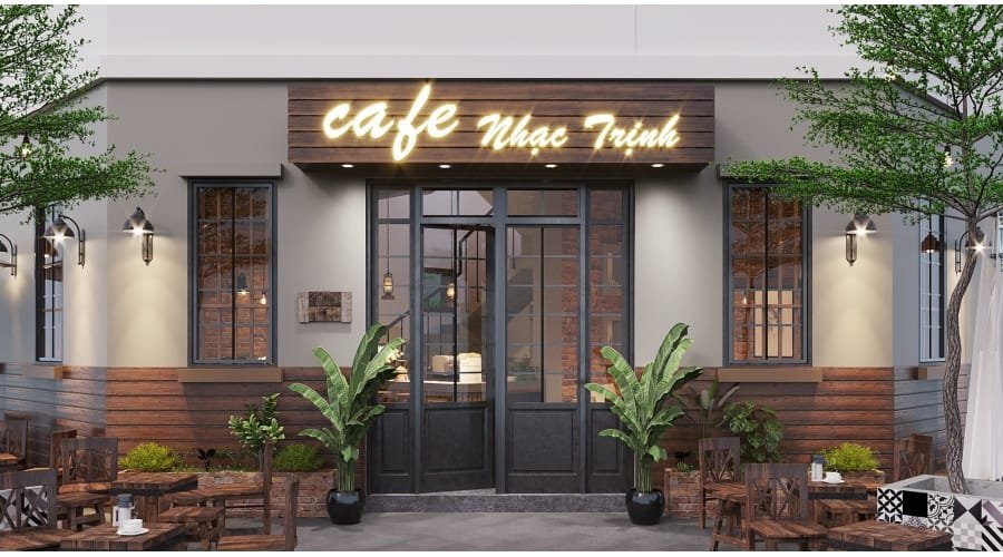 Mặt tiền quán cà phê với bảng hiệu sáng, cửa kính và cây xanh trang trí, bàn ghế ngoài trời.