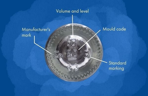 Nắp chai m&agrave;u bạc với c&aacute;c k&yacute; hiệu đ&aacute;nh dấu vị tr&iacute; m&atilde; khu&ocirc;n, ti&ecirc;u chuẩn, dung t&iacute;ch v&agrave; nh&atilde;n hiệu nh&agrave; sản xuất.