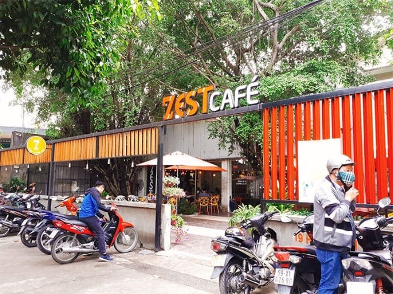 Gợi ý 14 quán cà phê chòi mát mẻ, thư giãn tại TPHCM 9 Quán cà phê với bảng hiệu "Zest Cafe", có nhiều xe máy đỗ phía trước và cây xanh bao quanh.