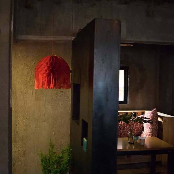 Kh&ocirc;ng gian nội thất ấm c&uacute;ng với đ&egrave;n ch&ugrave;m đỏ, b&agrave;n gỗ v&agrave; gối trang tr&iacute;, &aacute;nh s&aacute;ng dịu nhẹ.