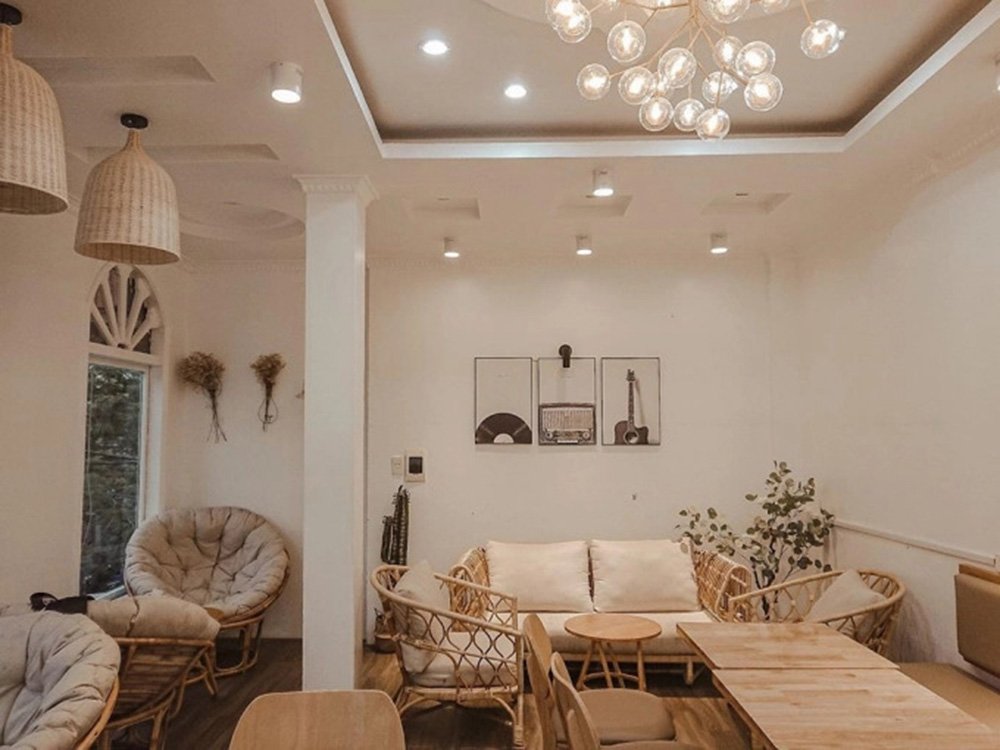 Qu&aacute;n c&agrave; ph&ecirc; ấm c&uacute;ng với nội thất gỗ, b&agrave;n ghế thoải m&aacute;i v&agrave; trang tr&iacute; đ&egrave;n trần s&aacute;ng tạo.