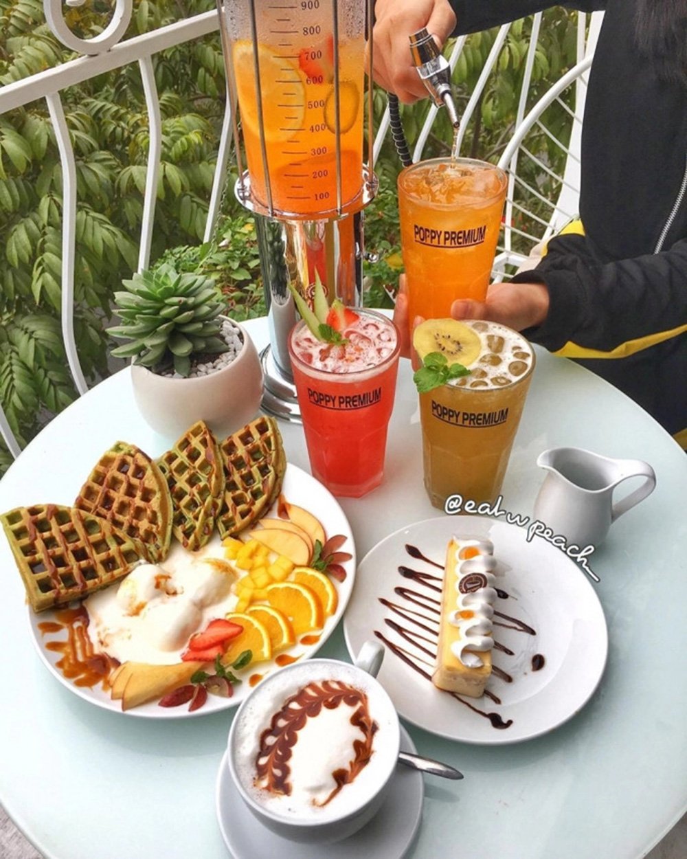 B&agrave;n tr&ograve;n với đồ ăn v&agrave; thức uống đa dạng, gồm b&aacute;nh quế, tr&aacute;i c&acirc;y, b&aacute;nh ngọt, c&agrave; ph&ecirc; v&agrave; nước tr&aacute;i c&acirc;y đầy m&agrave;u sắc.