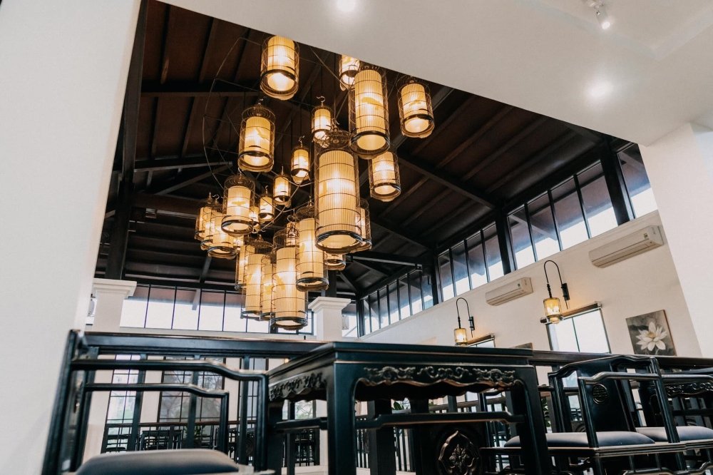 Đ&egrave;n lồng treo trần trong kh&ocirc;ng gian qu&aacute;n ăn với nội thất gỗ m&agrave;u đen v&agrave; &aacute;nh s&aacute;ng ấm &aacute;p.