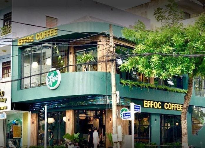 Top 32 thương hiệu nhượng quyền cafe siêu lợi nhuận 14 Quán cà phê hai tầng màu xanh, có cây xanh phía trước, với biển hiệu "EFFOC COFFEE" nổi bật ở tầng trên.