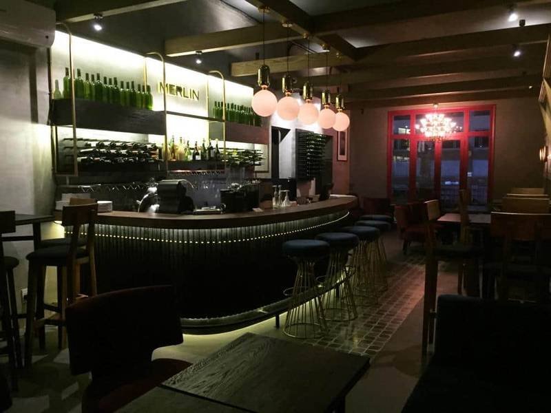 Quán bar với thiết kế hiện đại, ánh sáng ấm áp, quầy rượu và ghế ngồi xung quanh trong không gian sang trọng.