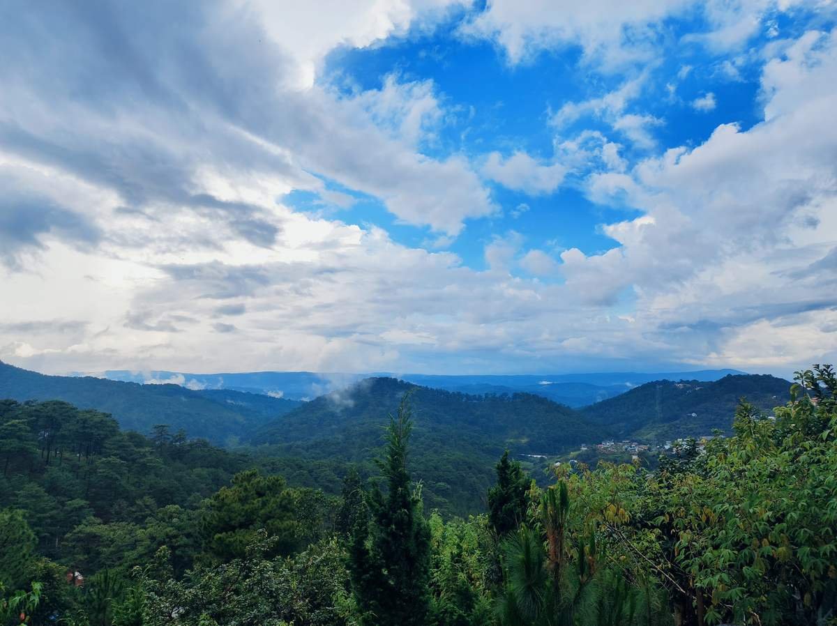 Bầu trời xanh v&agrave; m&acirc;y trắng tr&ecirc;n những ngọn đồi xanh tươi, tạo n&ecirc;n cảnh quan thi&ecirc;n nhi&ecirc;n y&ecirc;n b&igrave;nh v&agrave; rộng lớn.