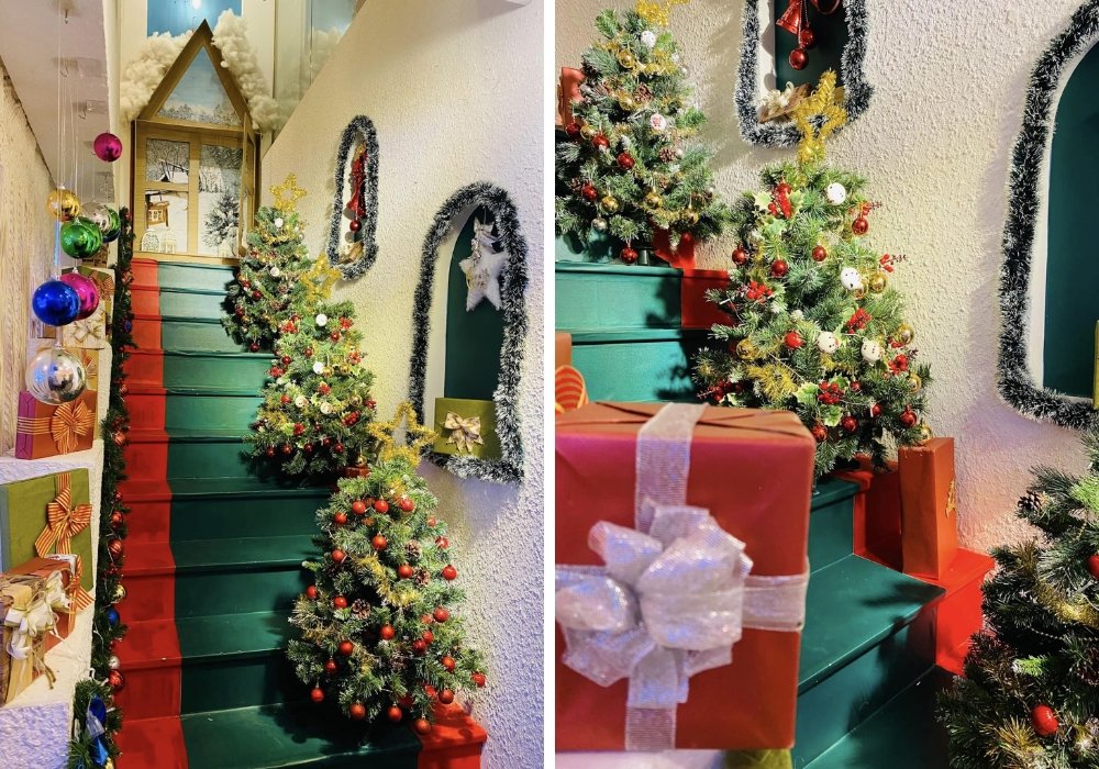 Cầu thang trang trí cây thông Noel và quà tặng, bóng đèn rực rỡ, tạo không khí lễ hội ấm áp.