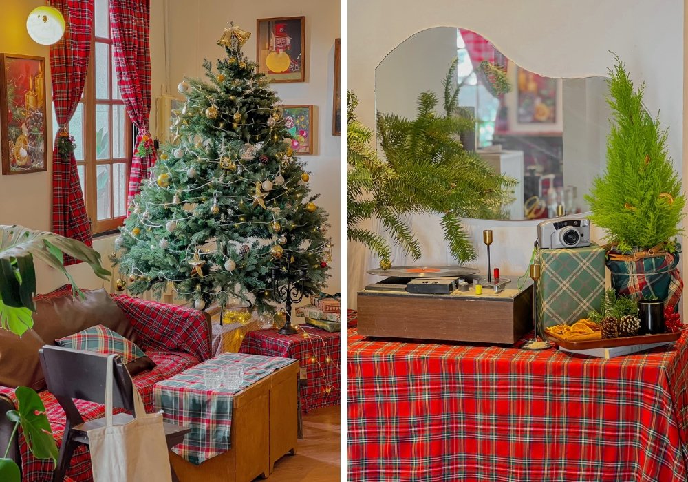 Phòng khách trang trí Giáng Sinh với cây thông, rèm caro đỏ, máy nghe nhạc và chậu cây xanh trên bàn.