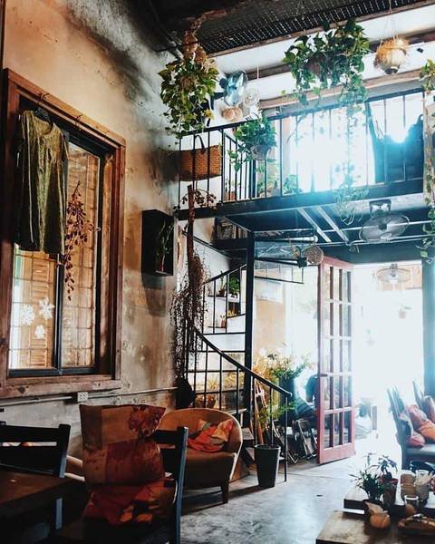 Qu&aacute;n c&agrave; ph&ecirc; phong c&aacute;ch vintage với nội thất gỗ, c&acirc;y xanh v&agrave; &aacute;nh s&aacute;ng tự nhi&ecirc;n từ cửa sổ lớn.