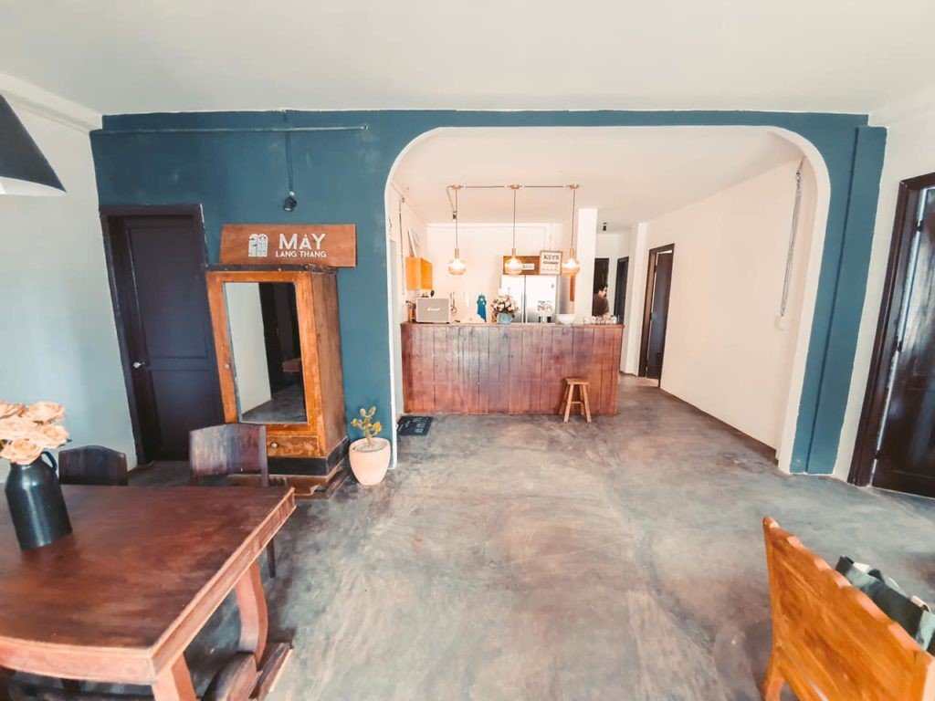 Qu&aacute;n c&agrave; ph&ecirc; nội thất gỗ mộc mạc với b&agrave;n ghế, quầy pha chế v&agrave; &aacute;nh s&aacute;ng ấm &aacute;p.