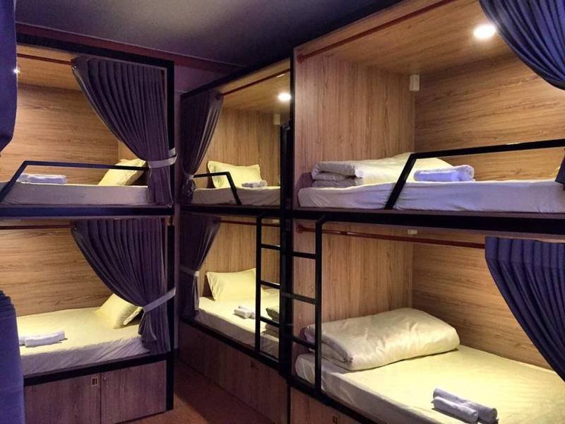 Giường tầng trong một ph&ograve;ng ngủ tập thể với r&egrave;m che v&agrave; &aacute;nh s&aacute;ng dịu nhẹ.