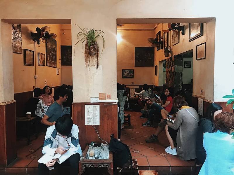 Qu&aacute;n c&agrave; ph&ecirc; nhỏ với nhiều người ngồi tr&ograve; chuyện, l&agrave;m việc v&agrave; thư gi&atilde;n trong kh&ocirc;ng gian ấm c&uacute;ng v&agrave; trang tr&iacute; đơn giản.