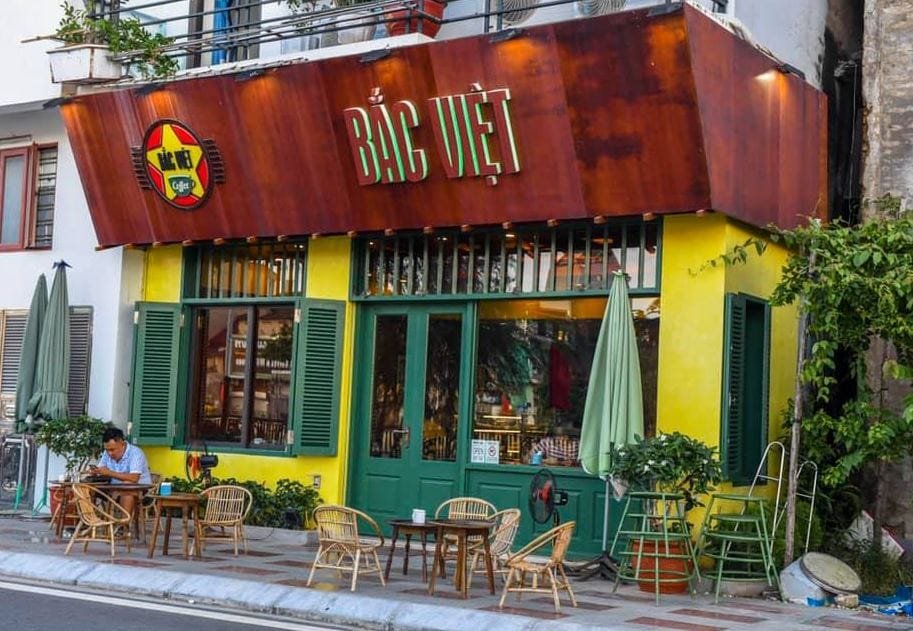 Top 32 thương hiệu nhượng quyền cafe siêu lợi nhuận 31 Quán cà phê với bảng hiệu "Bắc Việt", có bàn ghế ngoài trời và cây xanh bao quanh.