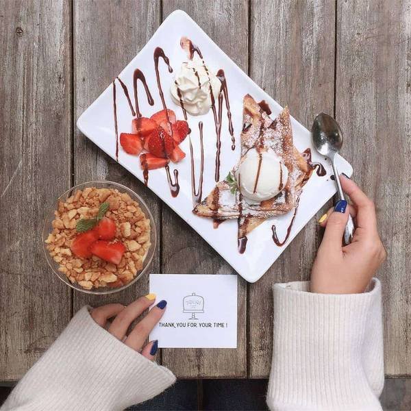 B&agrave;n gỗ với m&oacute;n tr&aacute;ng miệng gồm b&aacute;nh quế, kem, d&acirc;u t&acirc;y v&agrave; cốc ngũ cốc, b&ecirc;n cạnh c&oacute; thiệp cảm ơn nhỏ.