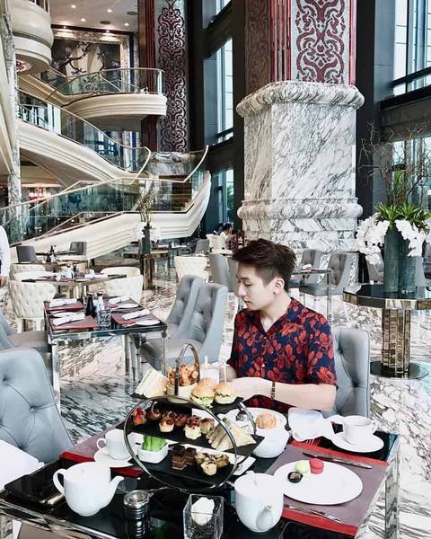 Người ngồi trong nh&agrave; h&agrave;ng sang trọng, tr&ecirc;n b&agrave;n c&oacute; nhiều m&oacute;n tr&aacute;ng miệng v&agrave; tr&agrave; chiều.