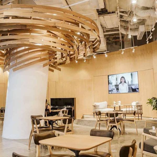 Qu&aacute;n c&agrave; ph&ecirc; hiện đại với nội thất gỗ, b&agrave;n ghế sắp xếp gọn g&agrave;ng, trần nh&agrave; thiết kế độc đ&aacute;o v&agrave; m&agrave;n h&igrave;nh lớn.