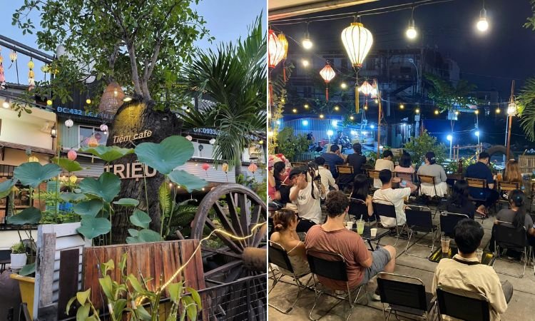 Qu&aacute;n c&agrave; ph&ecirc; ngo&agrave;i trời với c&acirc;y cối xanh tươi, đ&egrave;n lồng trang tr&iacute;, v&agrave; kh&aacute;ch ngồi thưởng thức kh&ocirc;ng gian buổi tối.