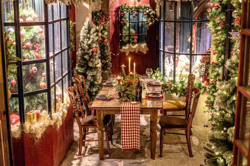 B&agrave;n ăn ấm c&uacute;ng được trang tr&iacute; với c&acirc;y th&ocirc;ng v&agrave; nến, xung quanh l&agrave; cửa sổ v&agrave; c&acirc;y th&ocirc;ng Gi&aacute;ng sinh lộng lẫy.