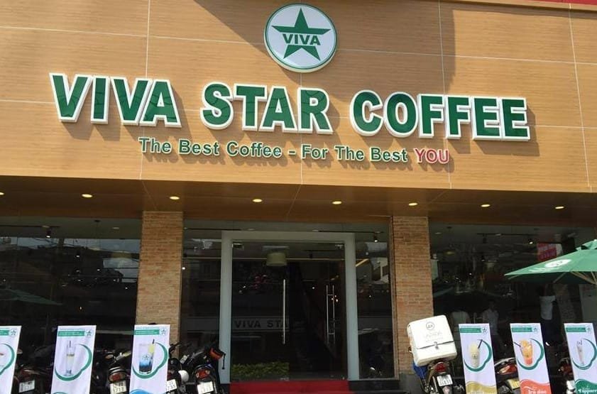 Top 32 thương hiệu nhượng quyền cafe siêu lợi nhuận 9 Mặt tiền quán cà phê với biển hiệu lớn, trang trí đơn giản và một số xe máy đỗ phía trước.